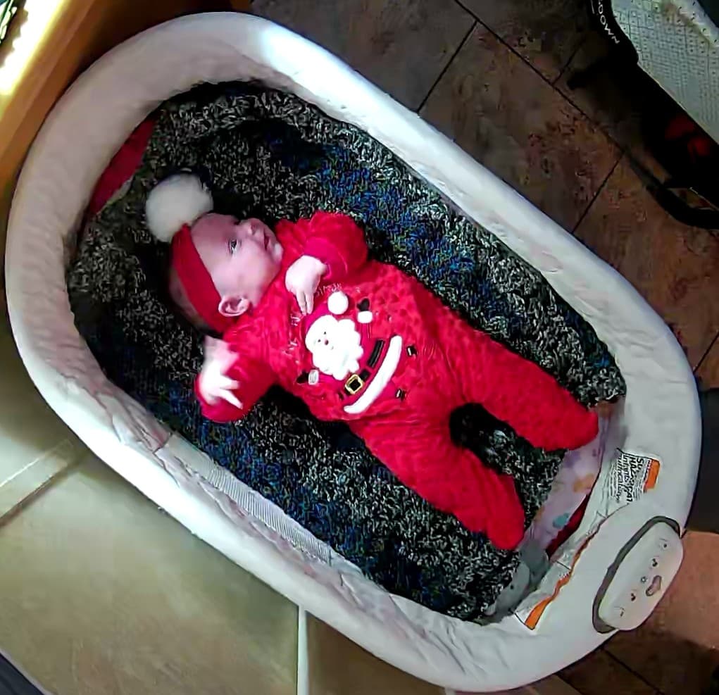 baby in a christmas outfit with a santa headband
