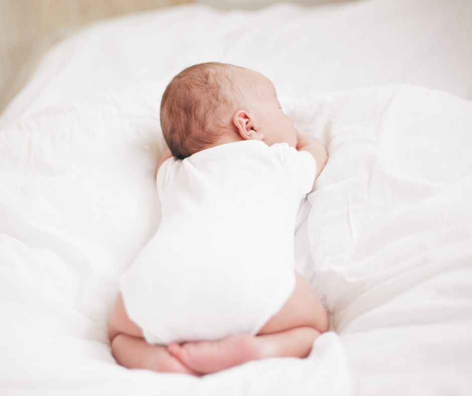 baby tummy sleep on a white bed sheet