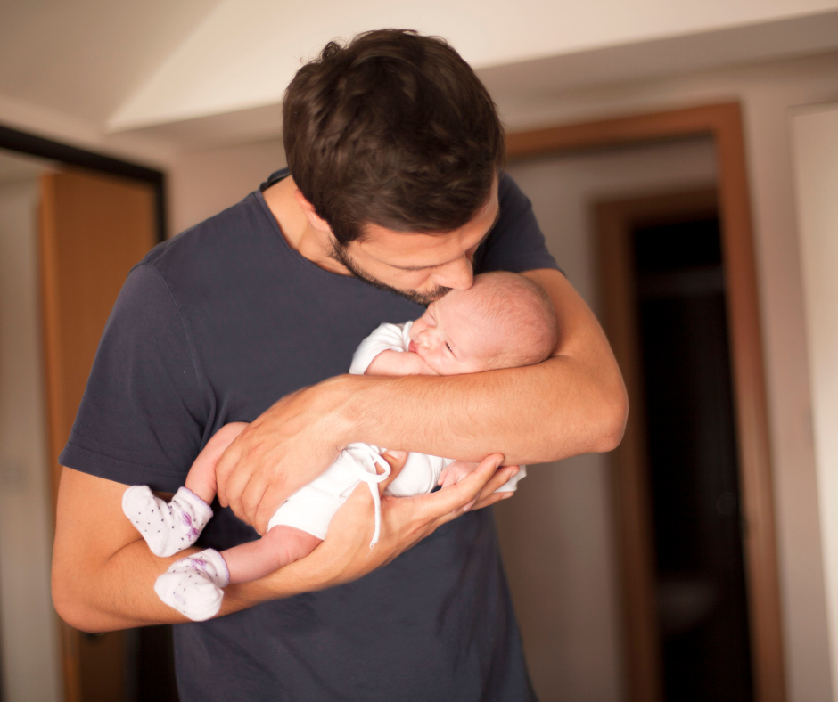 a baby sleeping in a man's arms