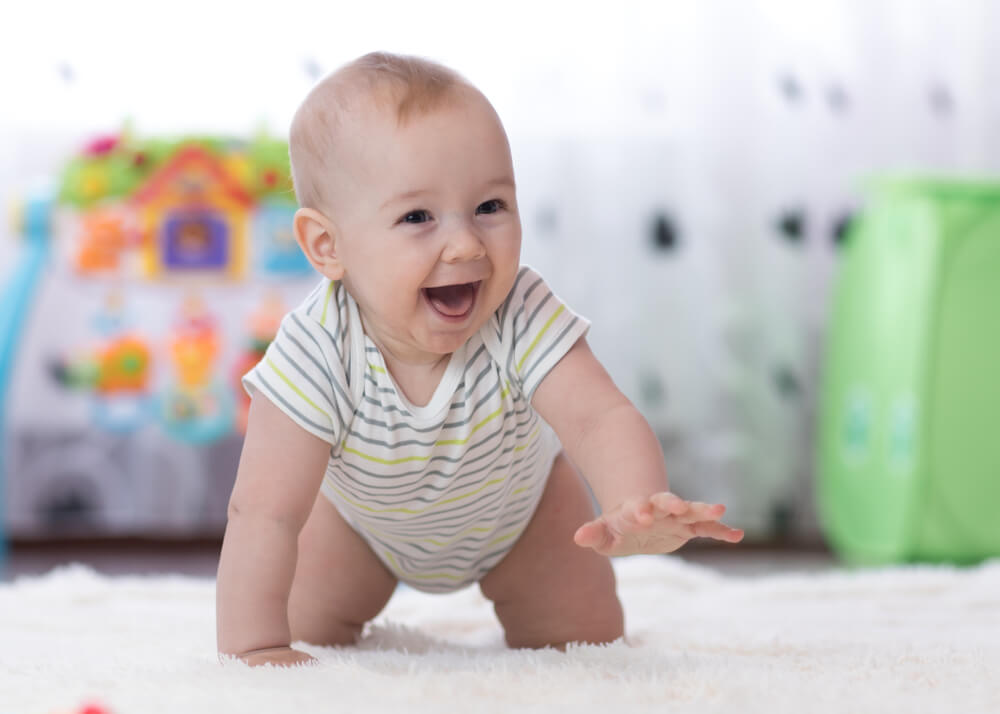 A happy baby in a safe crawling environment.